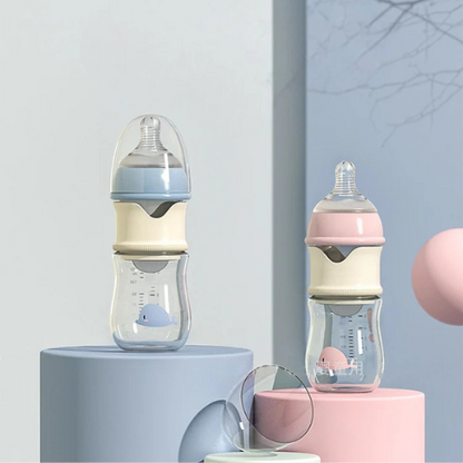 Two baby bottles, one blue and one pink, on colorful stands against a light gray background.